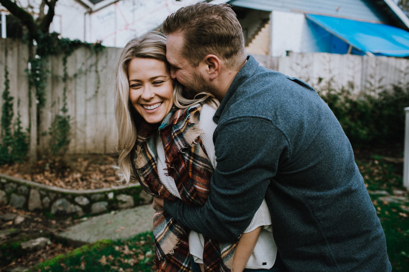 Man holding woman kissing side of face in backyard